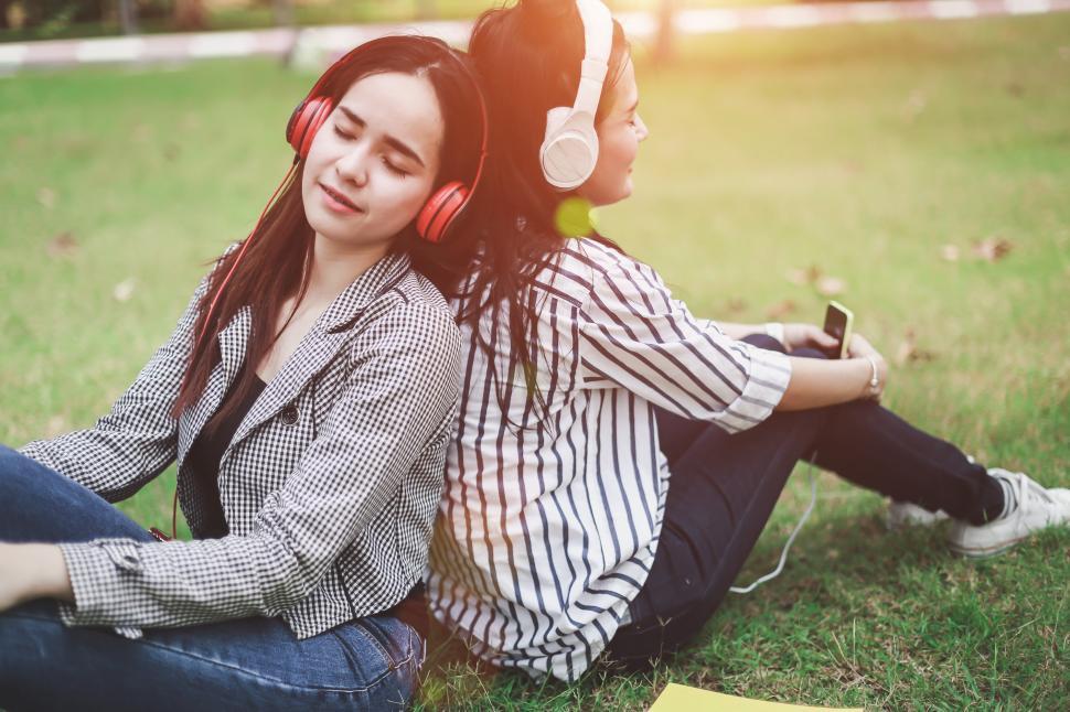 Free Image of Two women are resting on the lawn in the college 