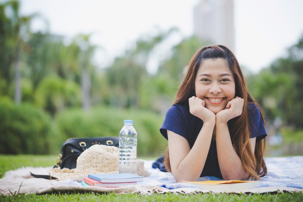 Free Image of Education concept - Happy woman laying in the grass 