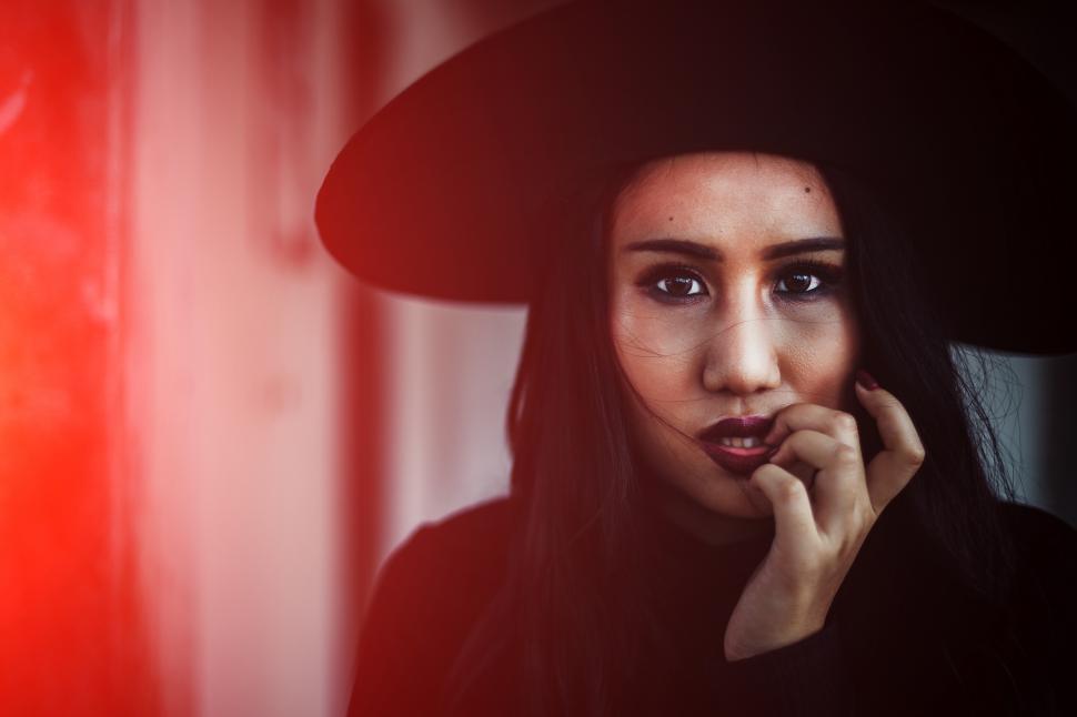 Free Image of Long hair young woman in black witch dress for Halloween 