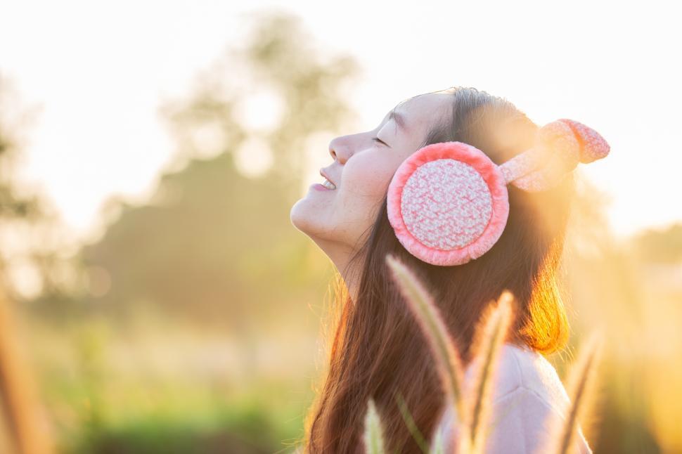 Free Image of Beautiful young woman in warm knitted clothe and earmuffs 