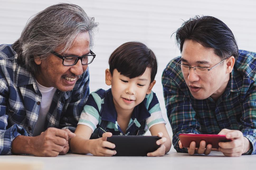 Free Image of Father and grandfather are teaching a little boy to use a smartphone 