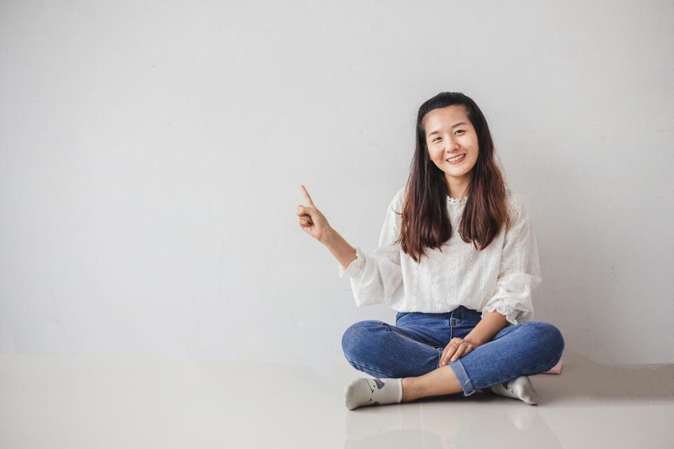 Free Image of Young women points at empty copyspace 
