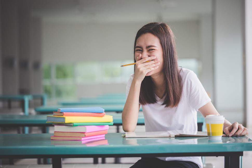 Free Image of Student stifling a laugh at her desk 