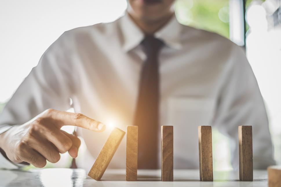 Free Image of Business man topples dominoes  