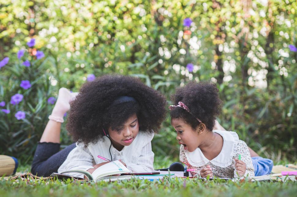 Free Image of Little girl is amazed by what her sister is doing 