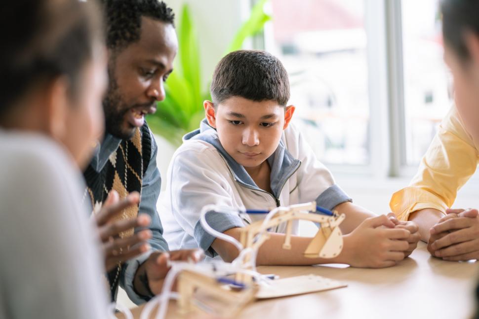 Free Image of Group of students watching teacher show science experiment  