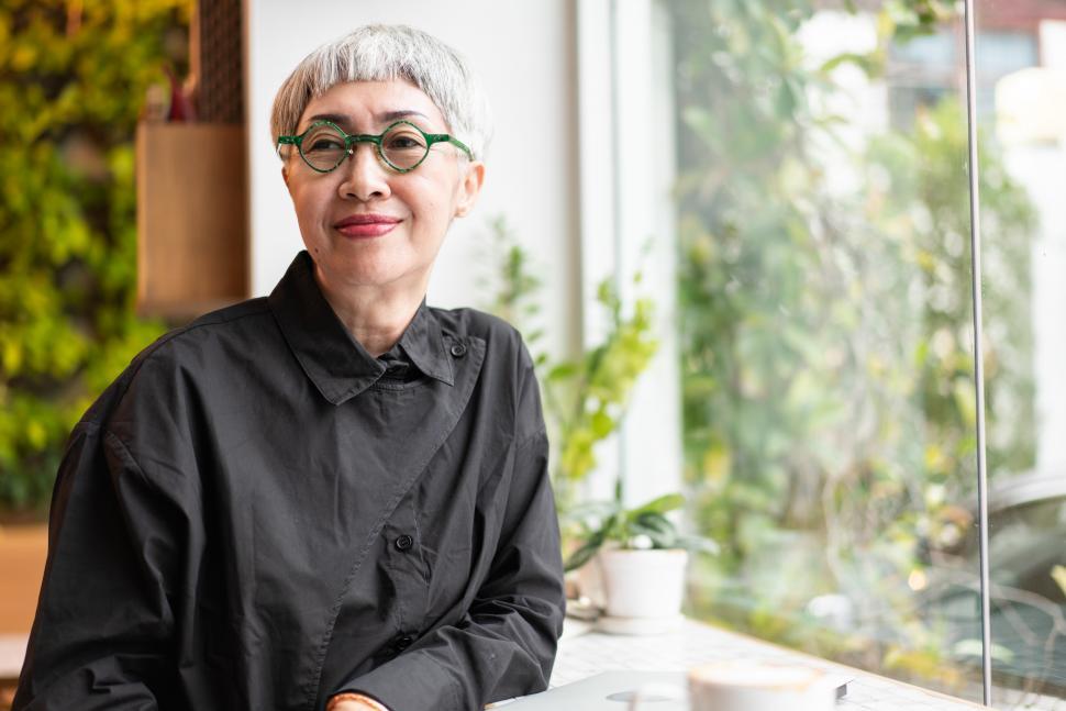 Free Image of Happy Asian hipster senior woman sitting in a coffee shop 