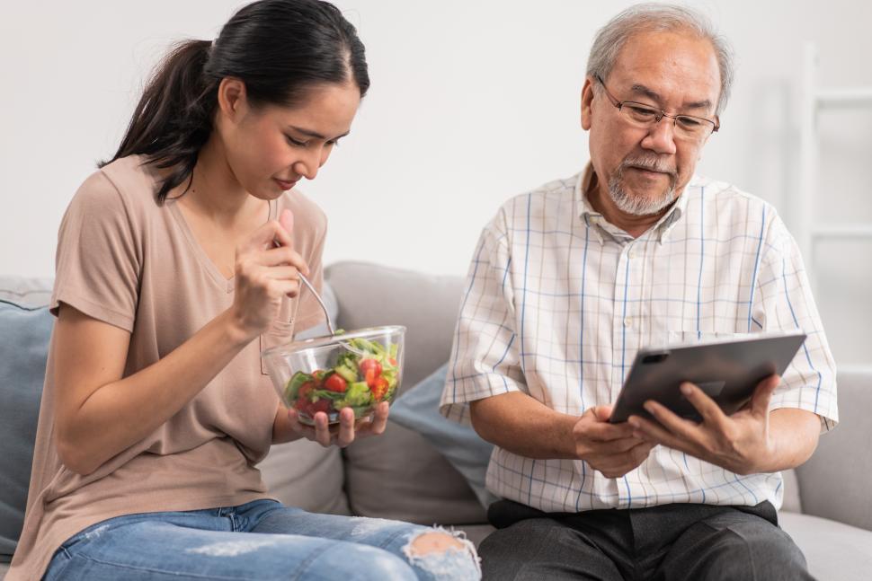 Free Image of Young daughter serving and feeding food to senior father 