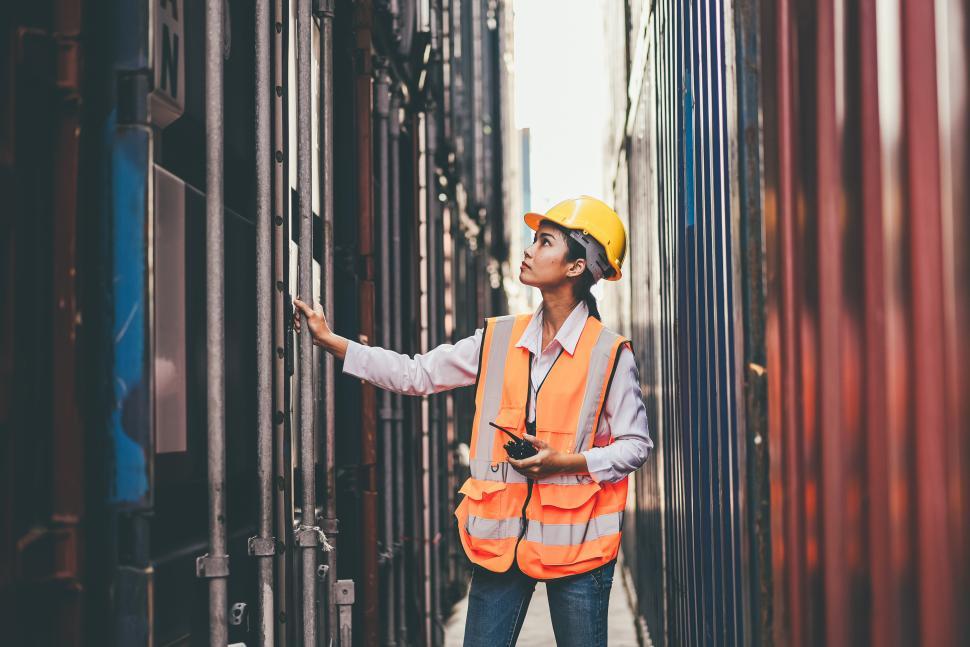 Free Image of Female worker checking container lock at warehouse 
