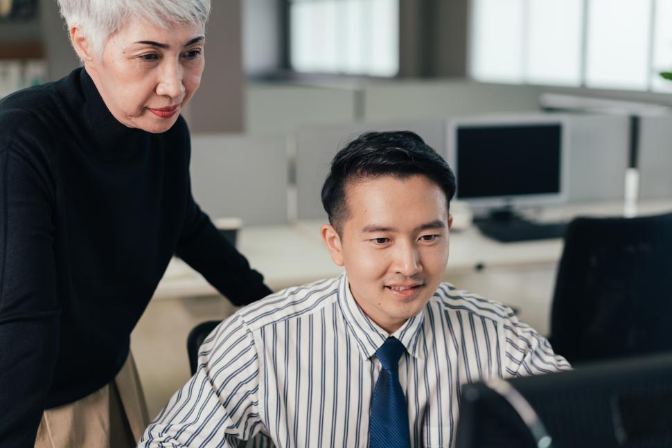 Free Image of Senior manager checking and discussing project on computer with junior staff 