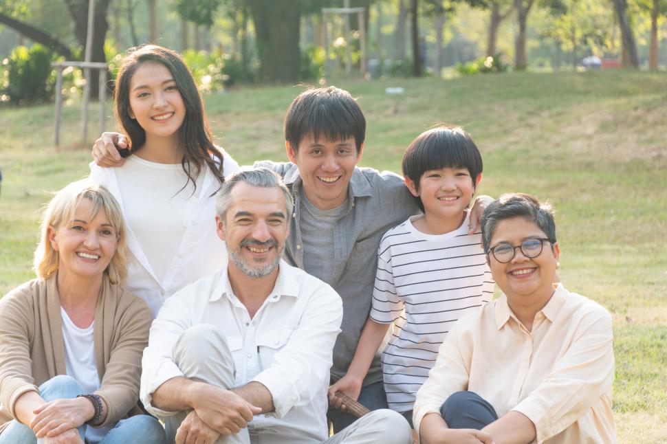 Free Image of Portrait group of diverse people sitting on grass and posing for photos 