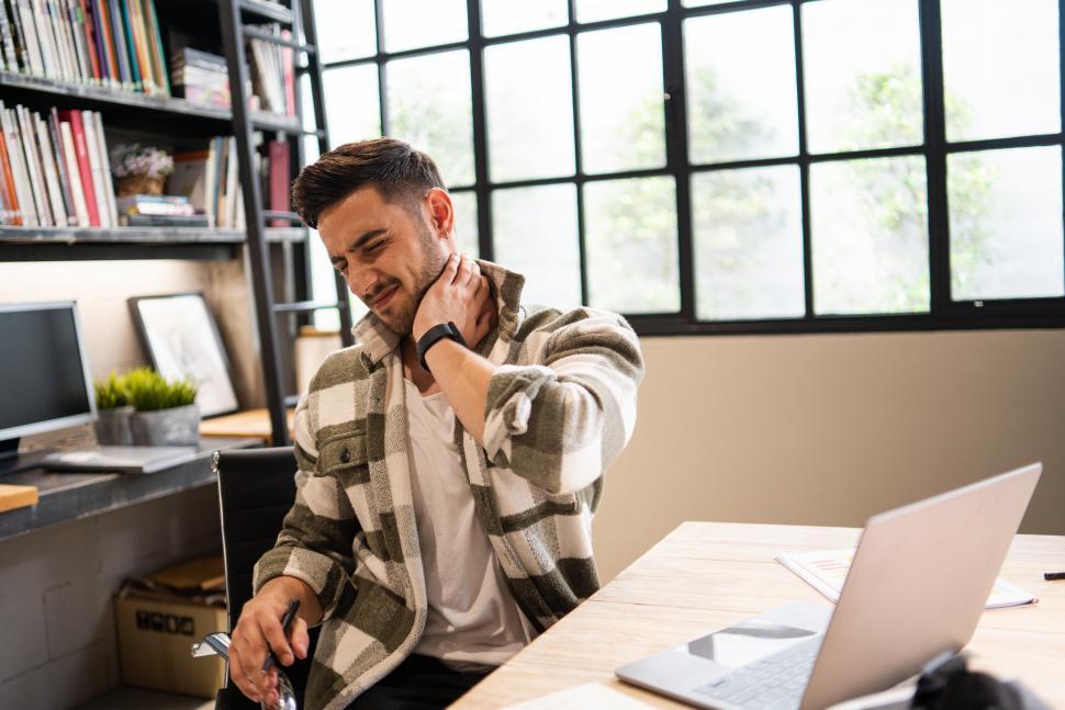 Free Image of Caucasian young creative designer suffering from office syndrome 