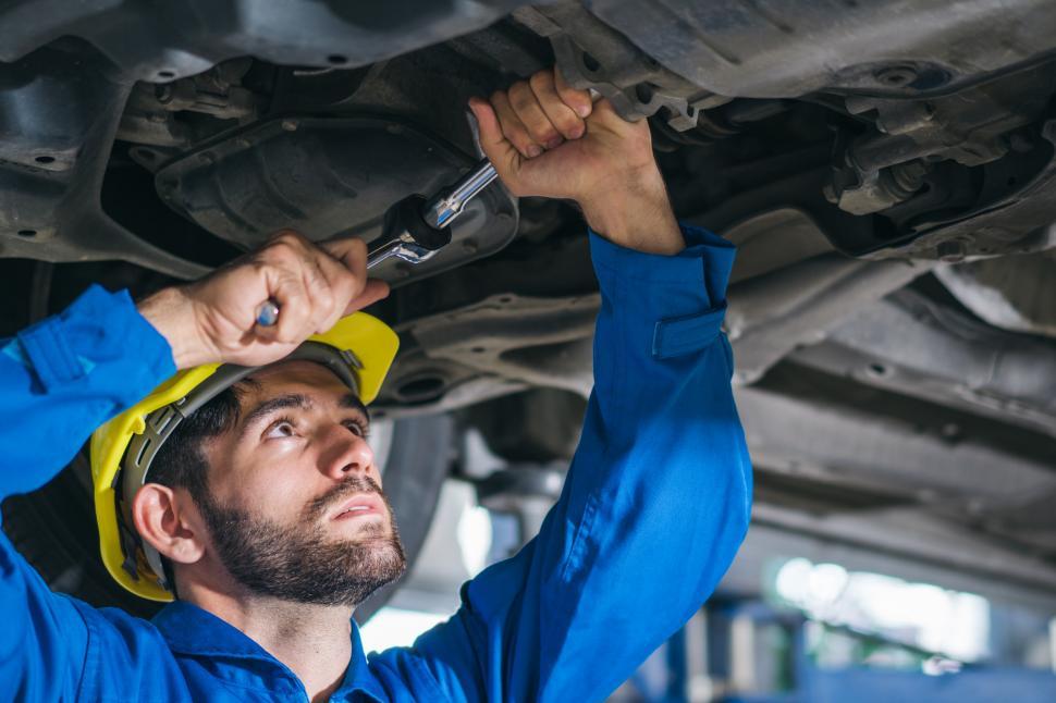 Free Image of Mechanic repairing car damage at auto shop 