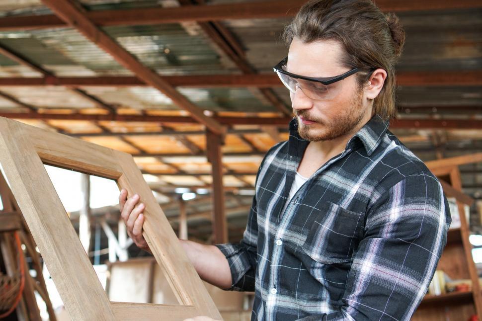 Free Image of Caucasian male carpenter showing wooden frame 