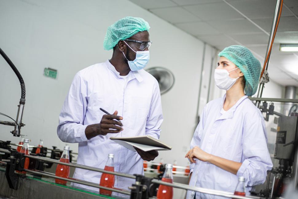 Free Image of Factory worker checking on drink production line 