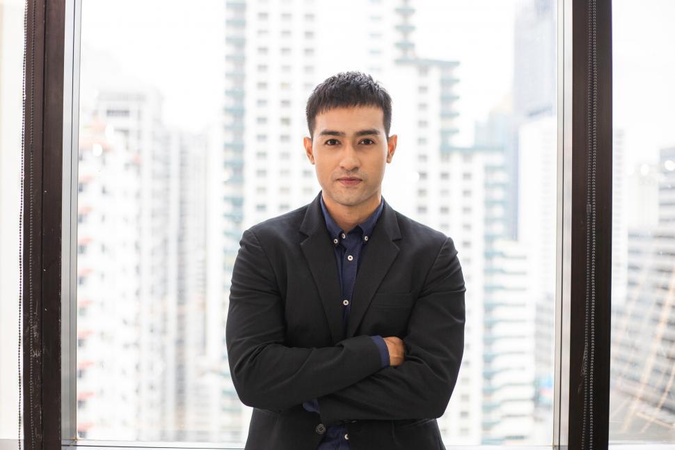 Free Image of Portrait of confident businessman standing with arms crossed 