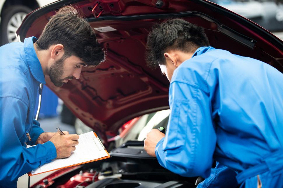 Free Image of Mechanic checking damage part under car hood 
