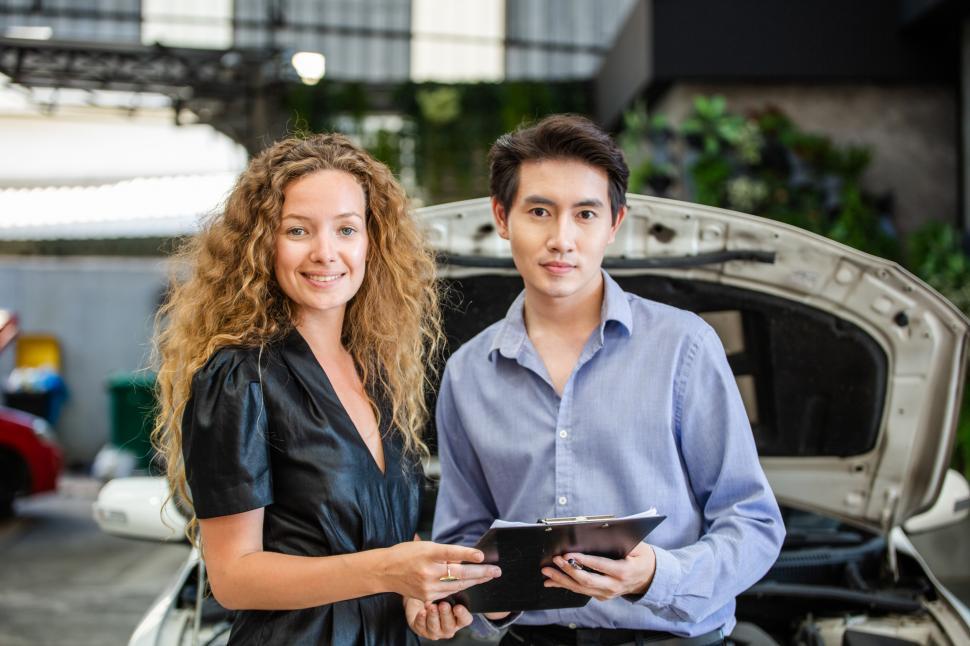 Free Image of Car salesman and customer holding agreement document 