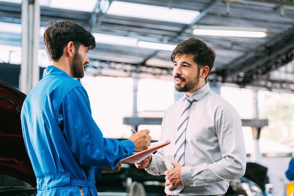 Free Image of Automotive maintenance mechanic explain car condition to male customer 