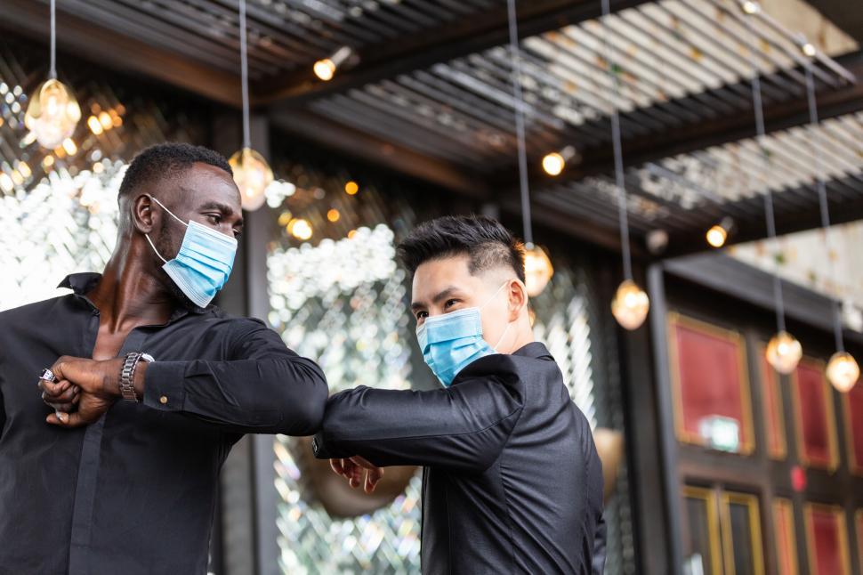 Free Image of People wearing medical mask elbow bumping greetings 