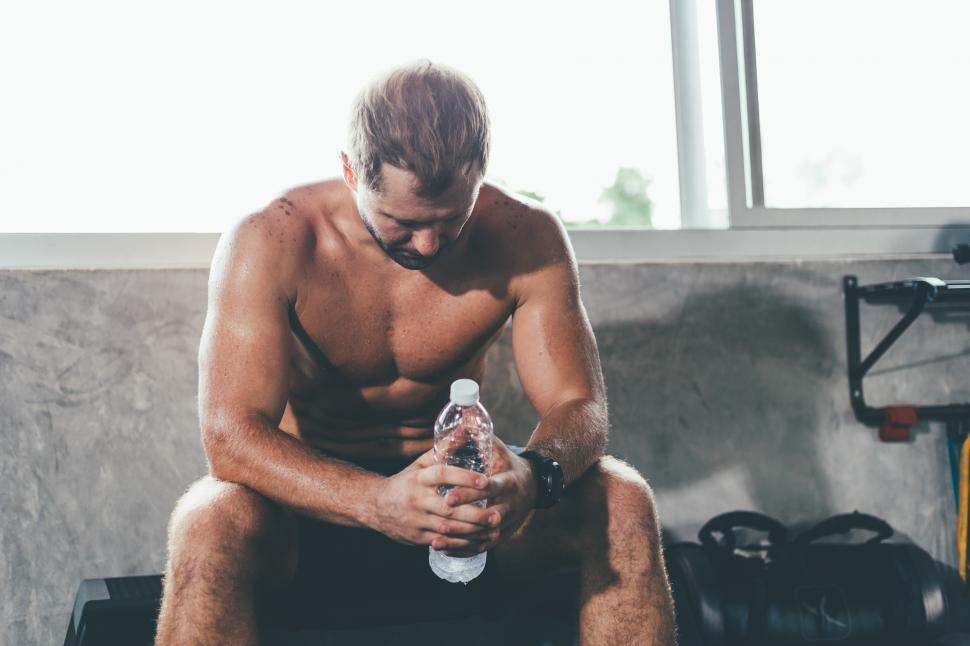 Free Image of Muscular man resting after exercise at the gym 