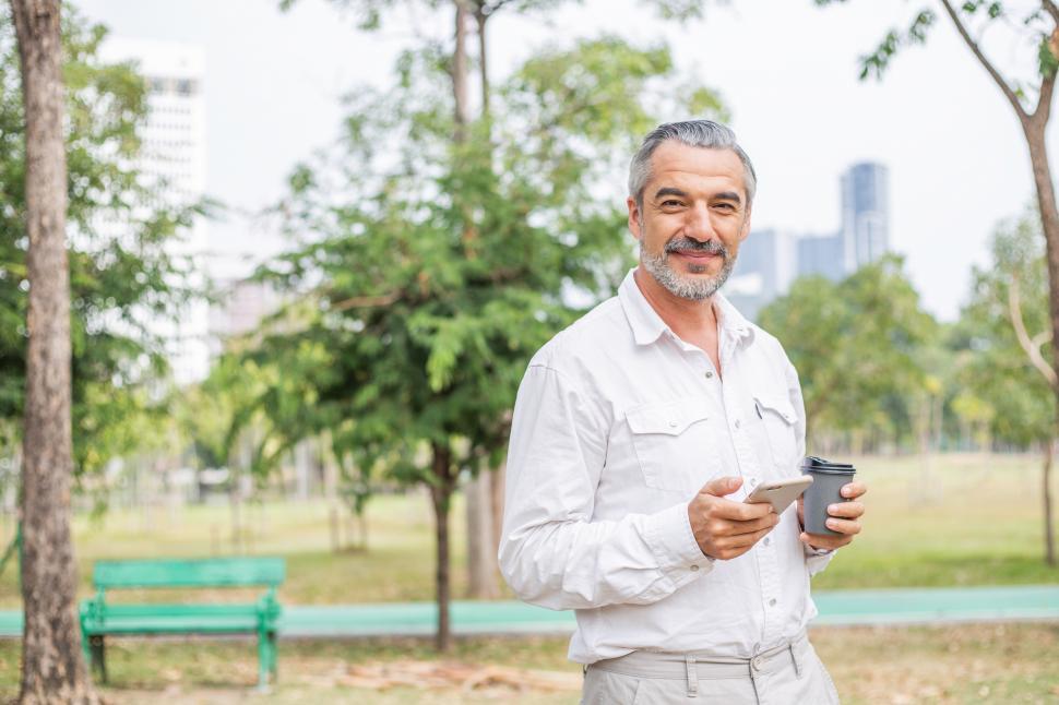 Free Image of Portrait of senior man with coffee at a park 