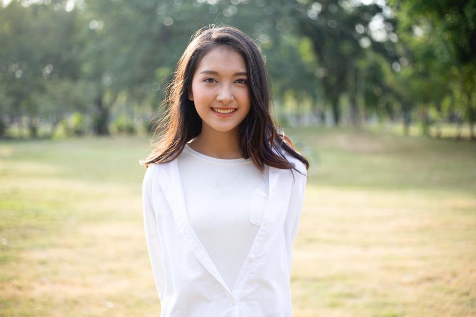Free Image of Portrait of Asian woman lookinging at camera at a park 