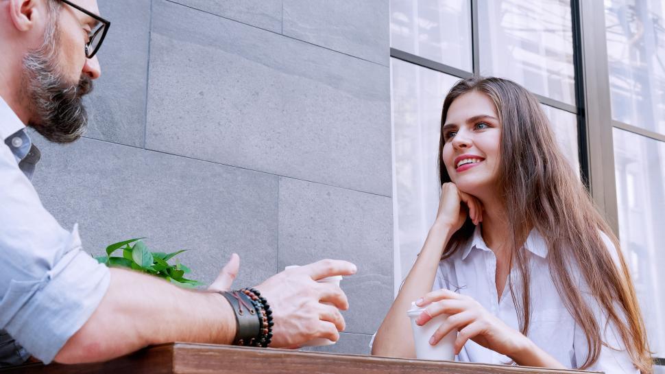 Free Image of Man and woman enjoying coffee and while sitting on cafe terrace 