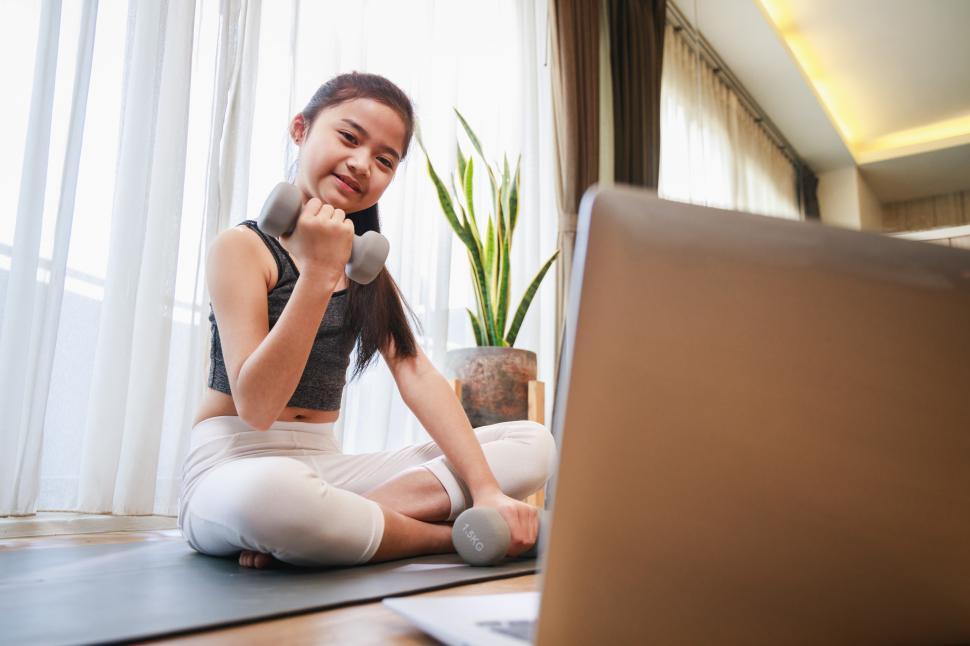 Free Image of Girl doing dumbbell exercise on yoga mat 