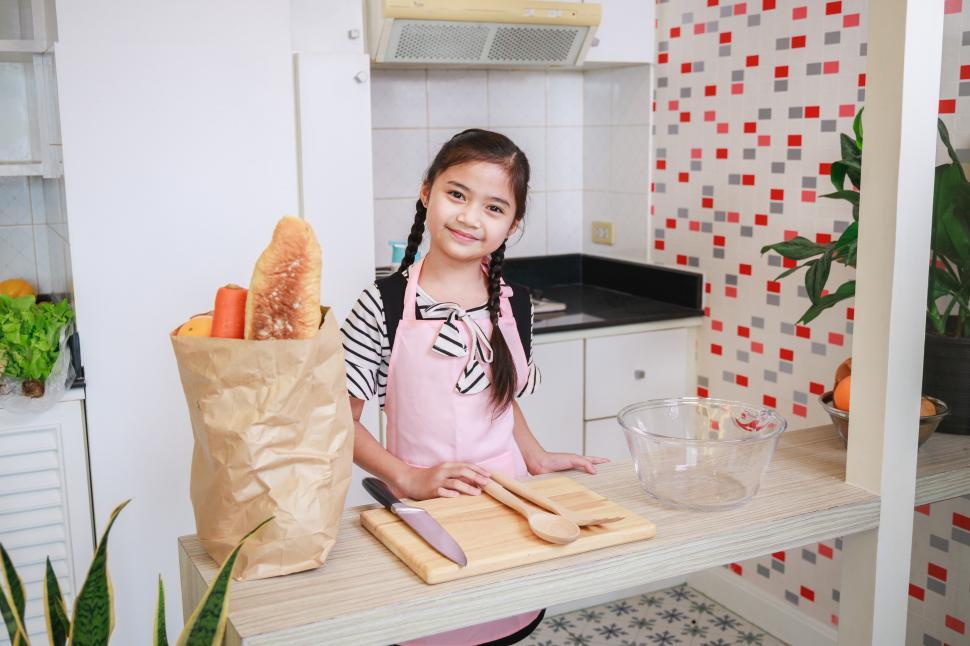 Free Image of Cute kid girl preparing to cook in a kitchen at home 