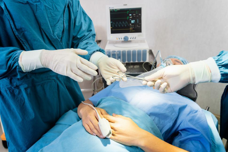 Free Image of Assistant Hands out Instruments to Surgeons During Operation 
