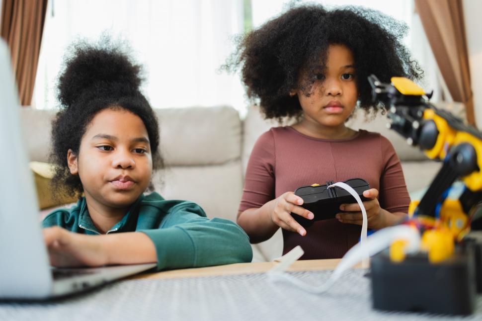 Free Image of Girl controls robotic arm with help from sister 