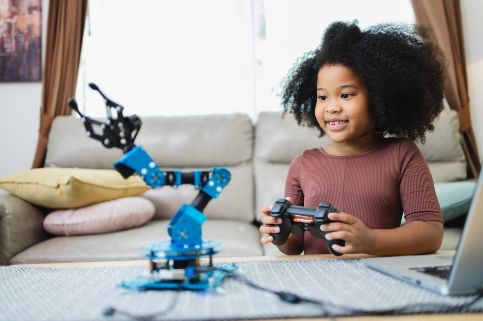 Free Image of Enthusiastic young STEM girl controls robot arm 