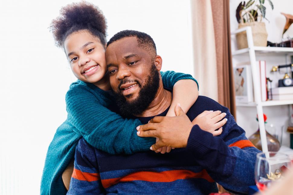 Free Image of Father and daughter wearing sweaters and hugging 