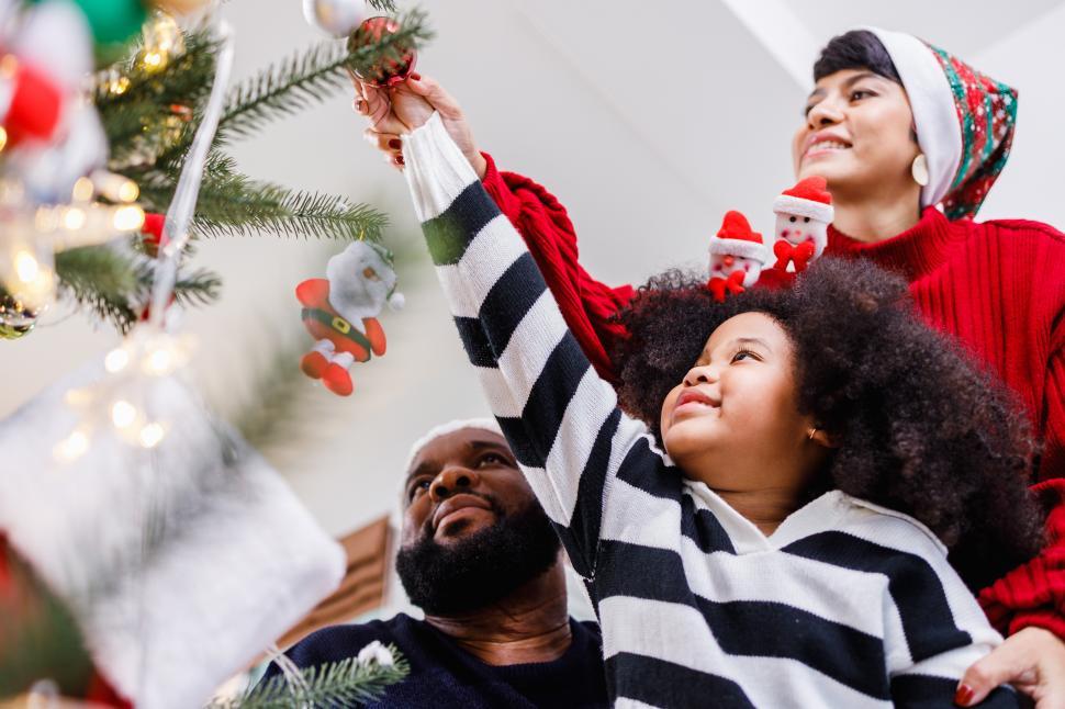 Free Image of Child helps parent decorate Christmas tree 
