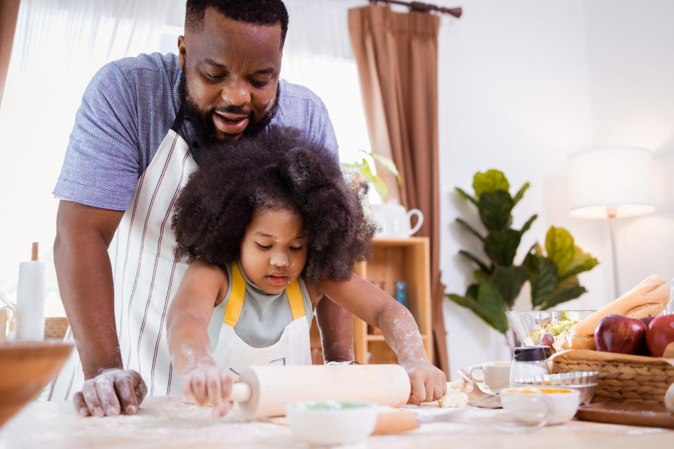 Free Image of Father and daughter rolling dough 