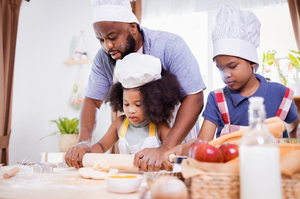 Free Image of Father and daughters baking together 