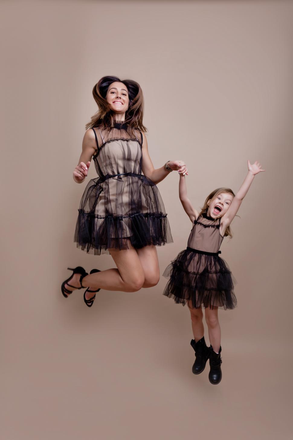 Free Image of Family shot of young mother with daughter jumping in air 