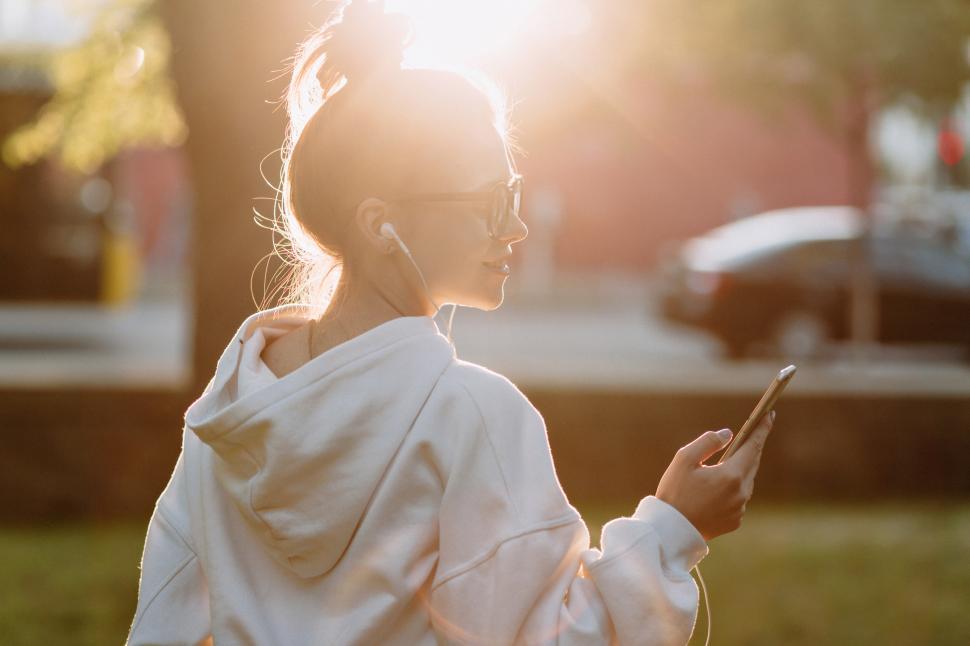 Free Image of Back view of lovely young female student listening to music 