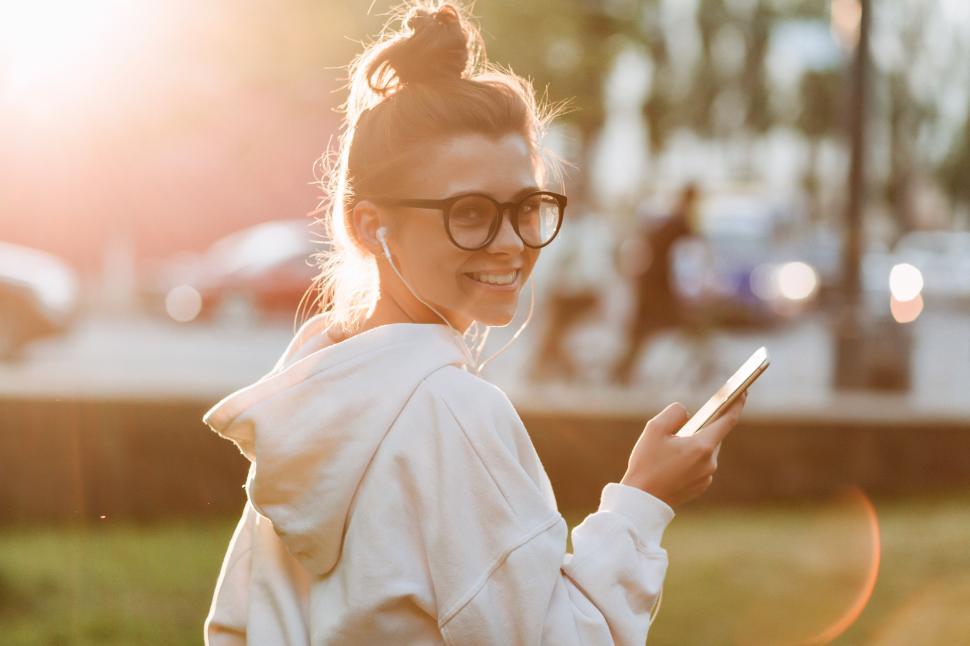 Free Image of Happy smiling young woman turns around at camera with headphones 