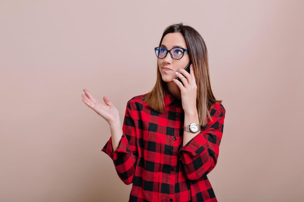 Free Image of Busy modern woman wears glasses talking on smartphone 