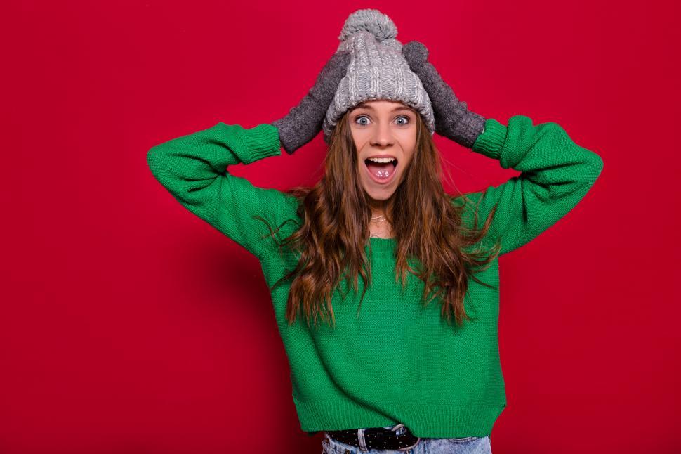 Free Image of Studio portrait of excited happy woman with hands on head 