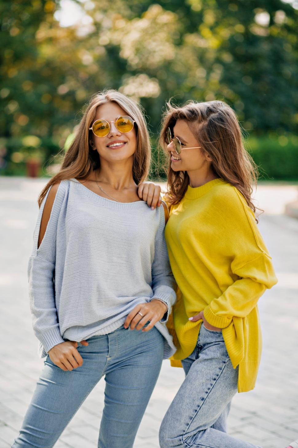 Free Image of Two happy funny hipster girls in bright glasses and pullovers 