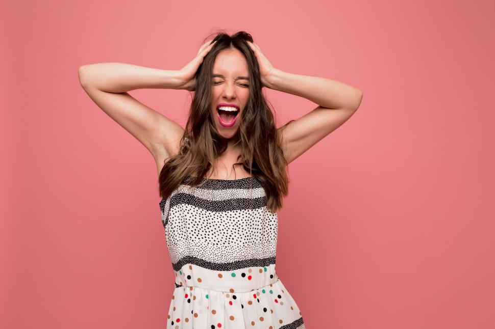 Free Image of Lovely excited woman holding her hands on the head and screaming 