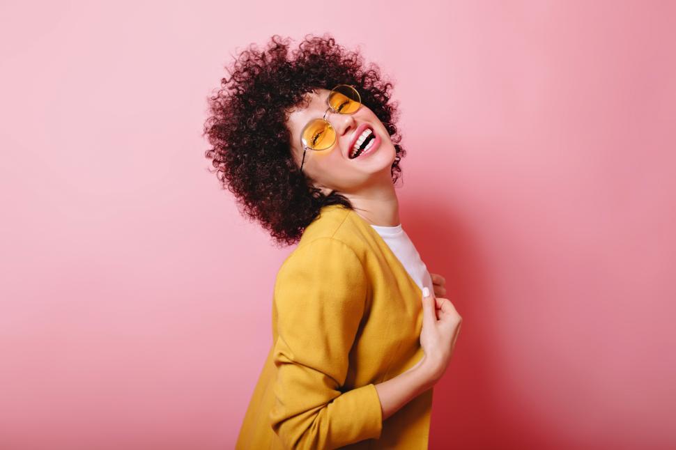 Free Image of Laughing girl with short ringlets dressed yellow jacket 