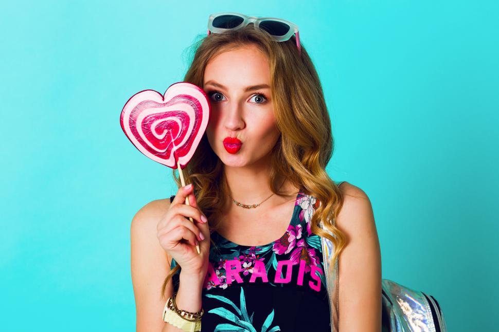 Free Image of Funny fashion crazy woman posing on blue wall background  