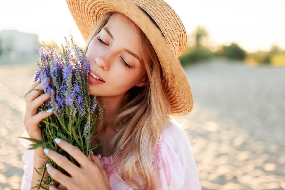 Free Image of Outdoor lifestyle portrait of graceful woman standing on sunny beach 