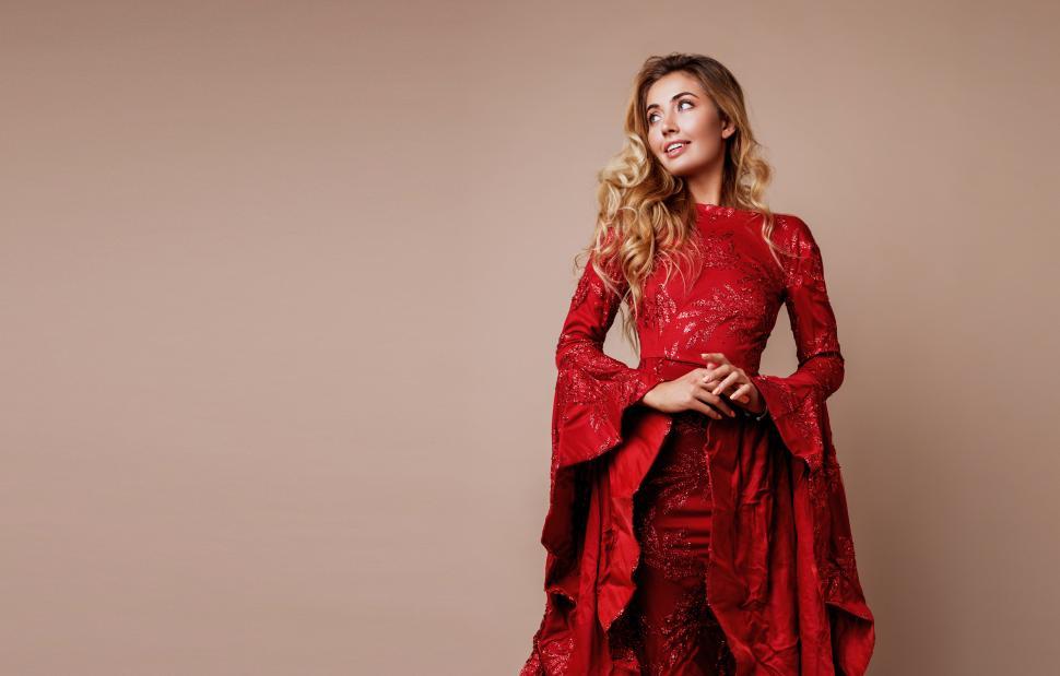 Free Image of Portrait of blonde woman with full lips, natural make up posing in studio in amazing luxury red dress 
