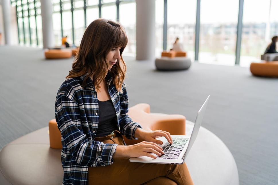 Free Image of Woman using laptop while sitting at airport lounge 