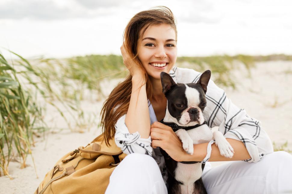 Free Image of Woman hugging her bulldog on the beach 
